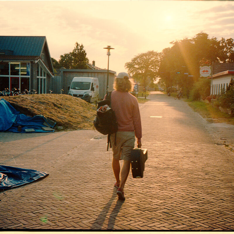 Max Berend walking with his guitar in Schiermonnikoog, the Netherlands, to illustrate the travel spirit of his news updates. This is the place where he wrote his debut album 'Red Little Paper Kite'.
