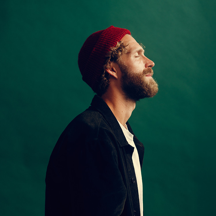 Max Berend, singer-songwriter, with his eyes closed, standing calmly and conveying a sense of serenity, reflecting the theme of his album On Serenity.